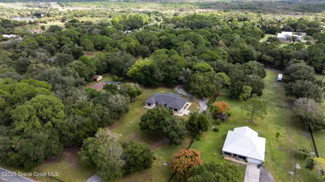 an aerial view of a house with a yard and lake view