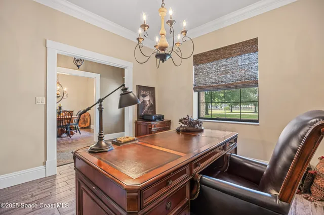 a room with a table chairs and a chandelier
