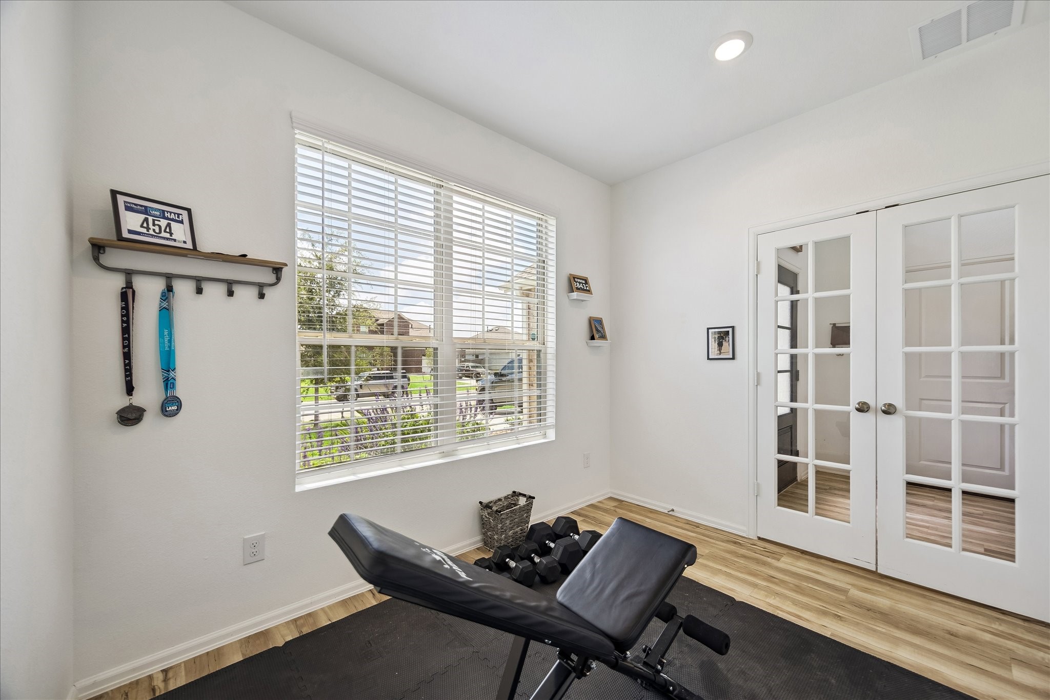 3812 Moss Hl Road Rosenberg, TX 77469 - Photo 9 of 20 Bright and airy home gym with a large window providing natural light. French doors add elegance and open up to the adjacent room. Could be a formal gathering space, study or playroom.