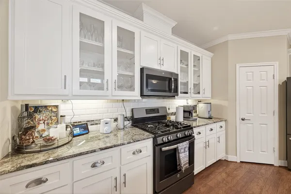 a kitchen with granite countertop white cabinets stainless steel appliances and a sink