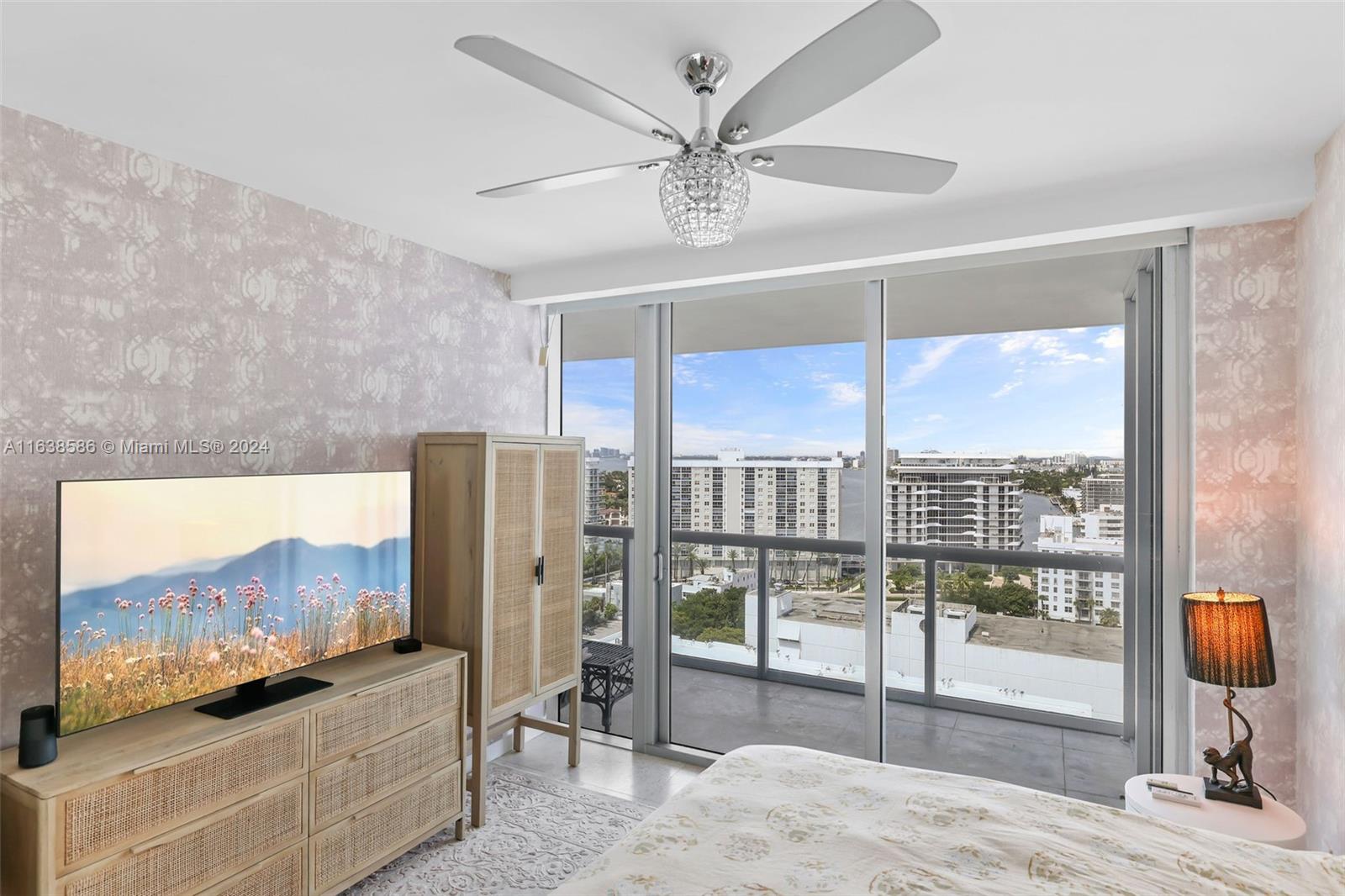 6799 Collins Avenue, Unit 1601 Miami Beach, FL 33141 - Photo 19 of 64 a living room with a flat screen tv and a floor to ceiling window