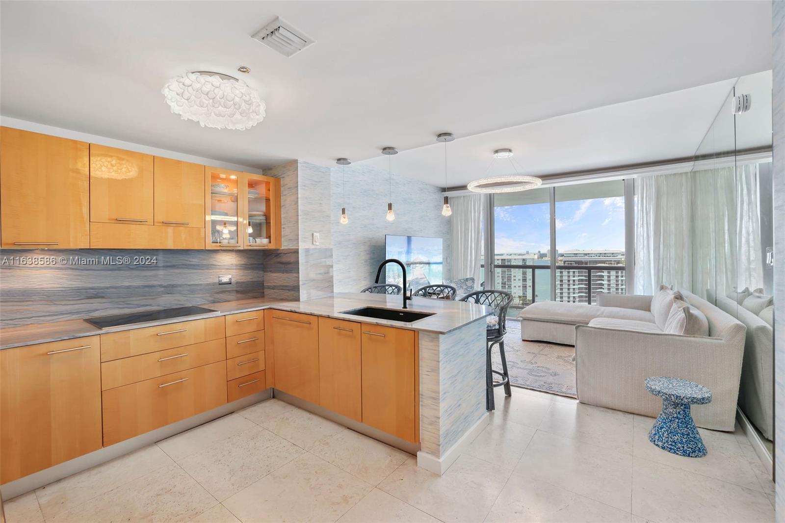 6799 Collins Avenue, Unit 1601 Miami Beach, FL 33141 - Photo 2 of 64 a kitchen with a sink and living room