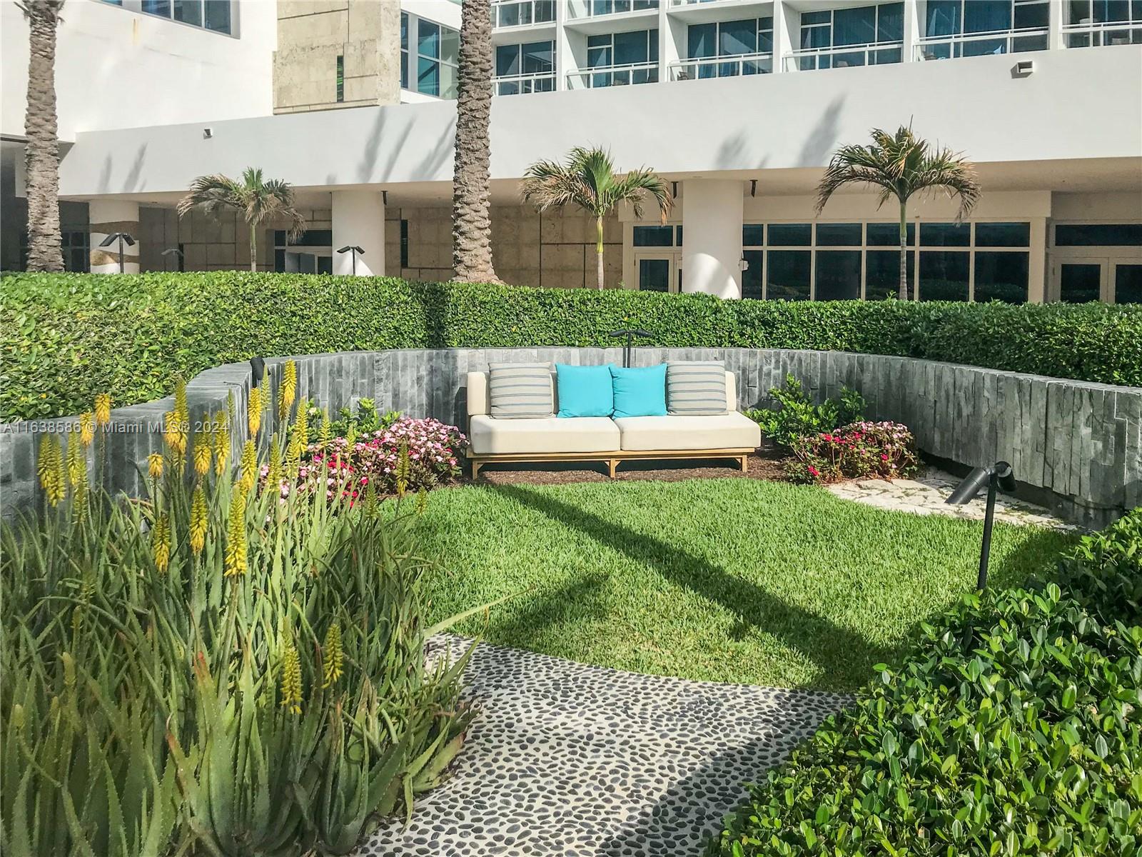 6799 Collins Avenue, Unit 1601 Miami Beach, FL 33141 - Photo 34 of 64 a front view of a house with a yard table and chairs