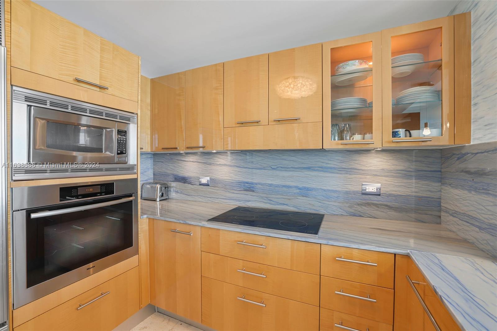 6799 Collins Avenue, Unit 1601 Miami Beach, FL 33141 - Photo 4 of 64 a kitchen with granite countertop cabinets stainless steel appliances and a counter space
