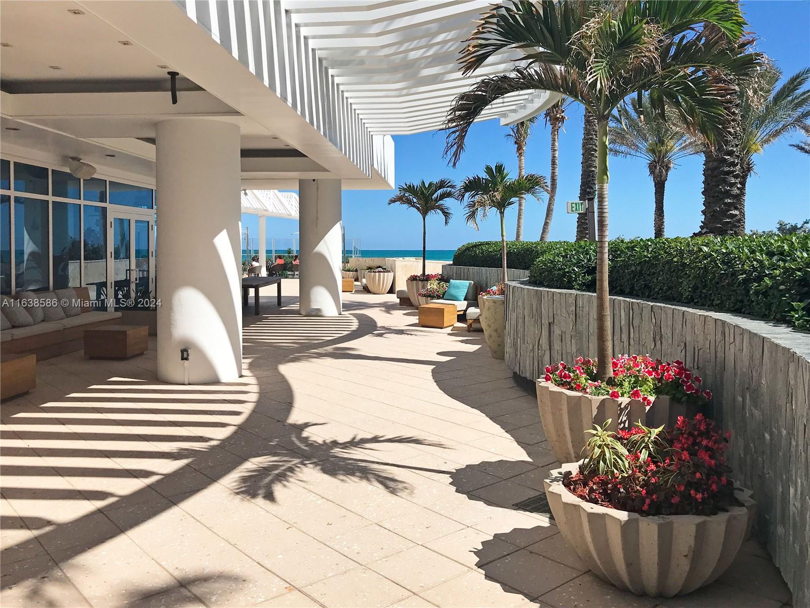 6799 Collins Avenue, Unit 1601 Miami Beach, FL 33141 - Photo 49 of 64 a view of a patio with a table and chairs and potted plants