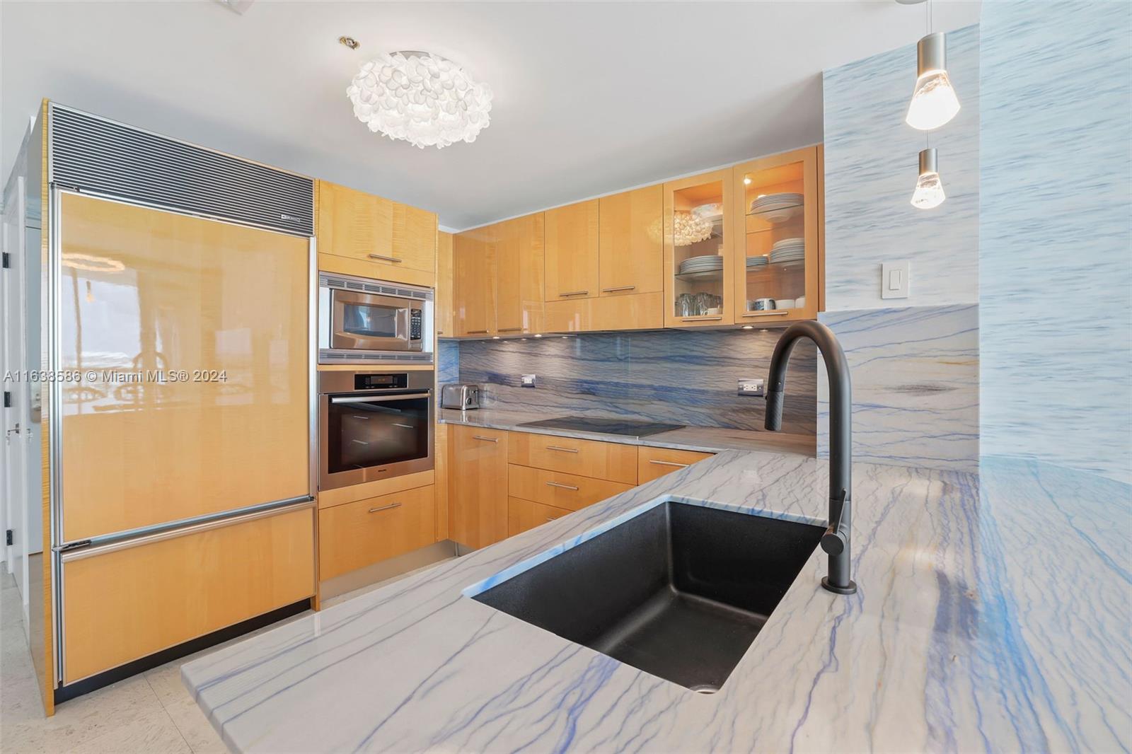 6799 Collins Avenue, Unit 1601 Miami Beach, FL 33141 - Photo 5 of 64 a kitchen with granite countertop stainless steel appliances and wooden floor