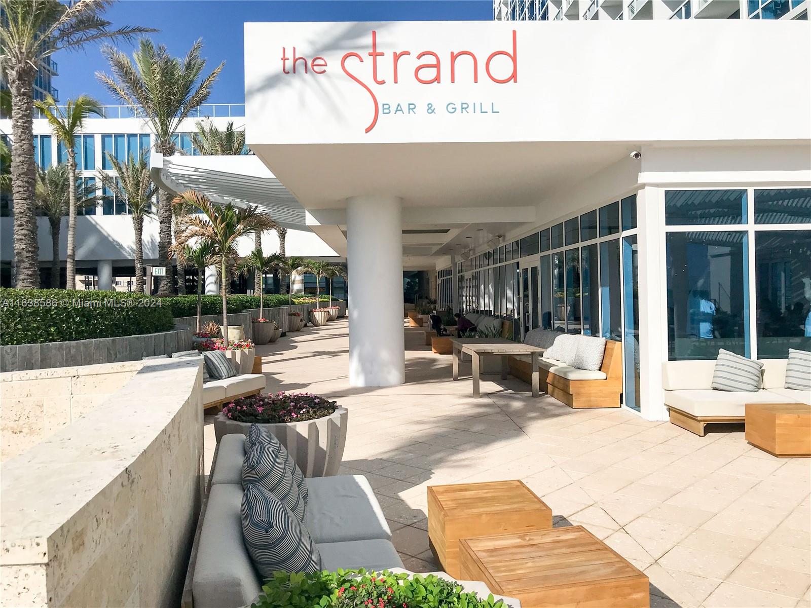 6799 Collins Avenue, Unit 1601 Miami Beach, FL 33141 - Photo 51 of 64 a view of a patio with table and chairs with wooden floor