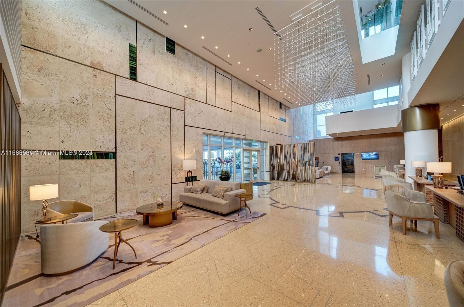6799 Collins Avenue, Unit 1601 Miami Beach, FL 33141 - Photo 63 of 64 a living room with furniture and a chandelier