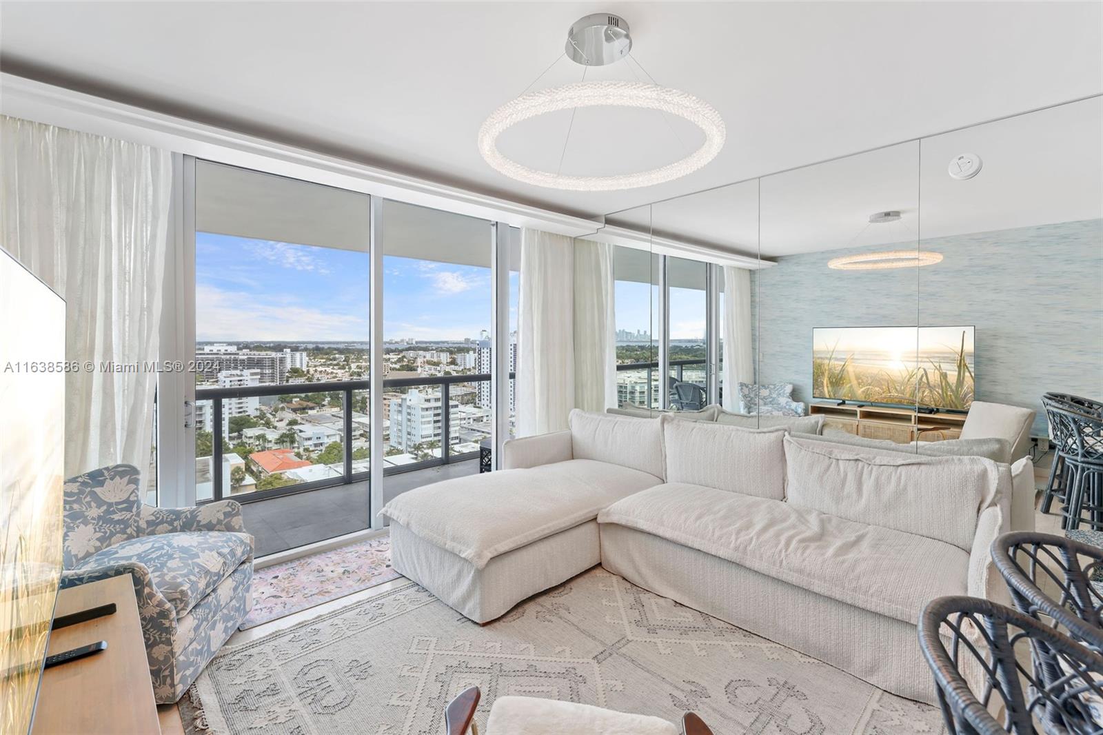 6799 Collins Avenue, Unit 1601 Miami Beach, FL 33141 - Photo 9 of 64 a living room with furniture and a flat screen tv