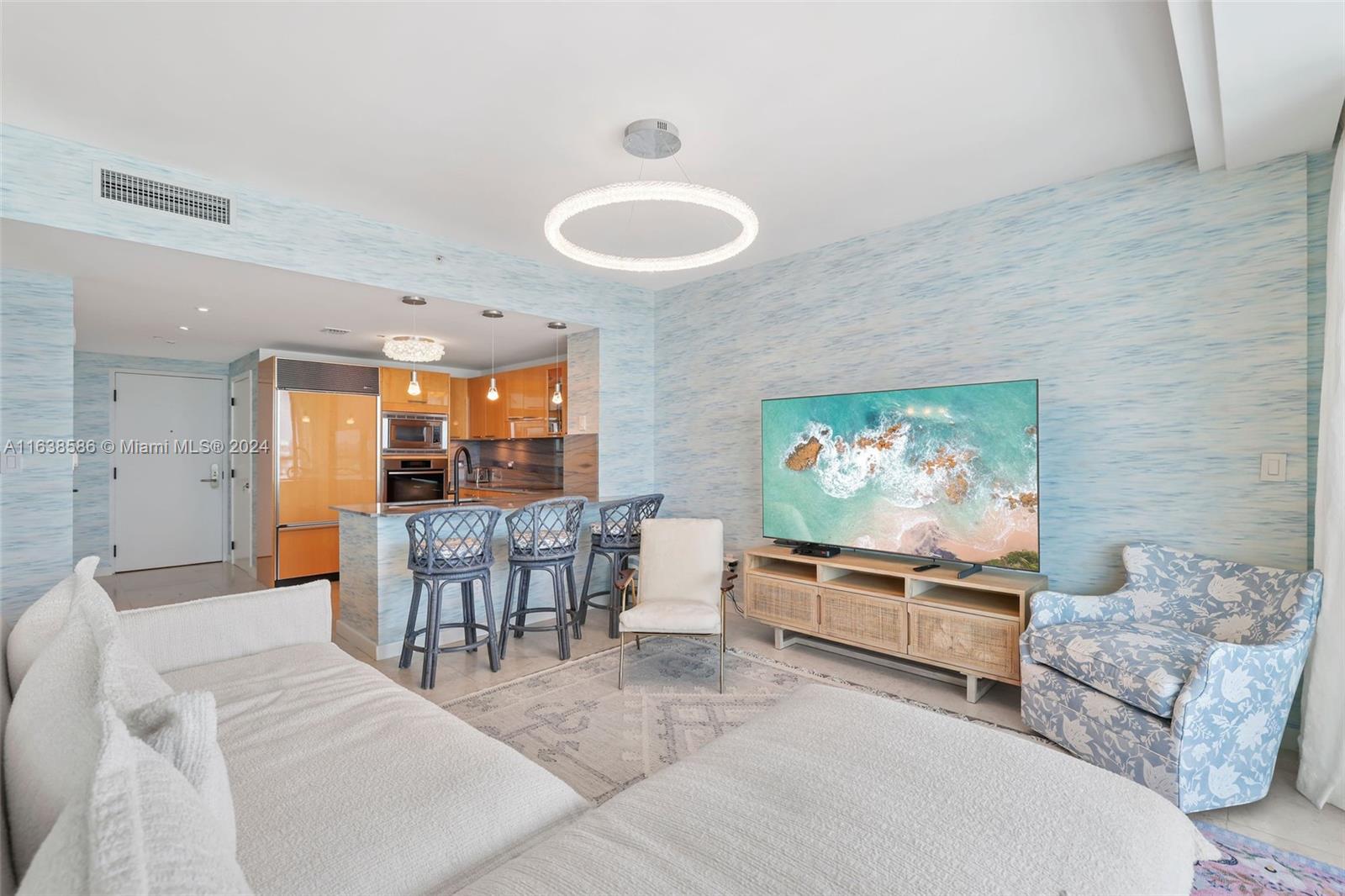 6799 Collins Avenue, Unit 1601 Miami Beach, FL 33141 - Photo 10 of 64 a living room with furniture and a flat screen tv