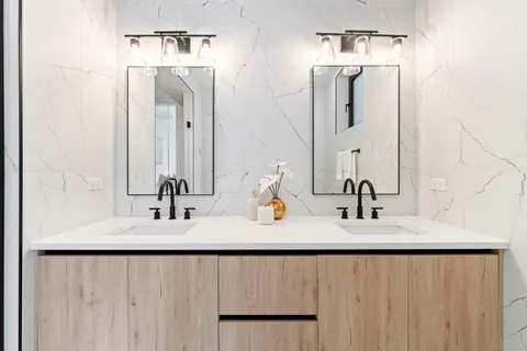 a bathroom with double vanity sinks and a mirror