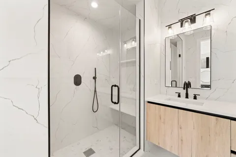 a bathroom with a shower sink and mirror