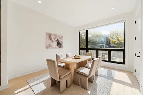 a dining room with furniture large windows and a rug