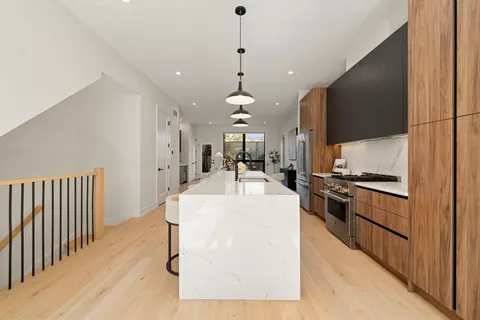 a kitchen with stainless steel appliances kitchen island granite countertop a sink a stove and a refrigerator