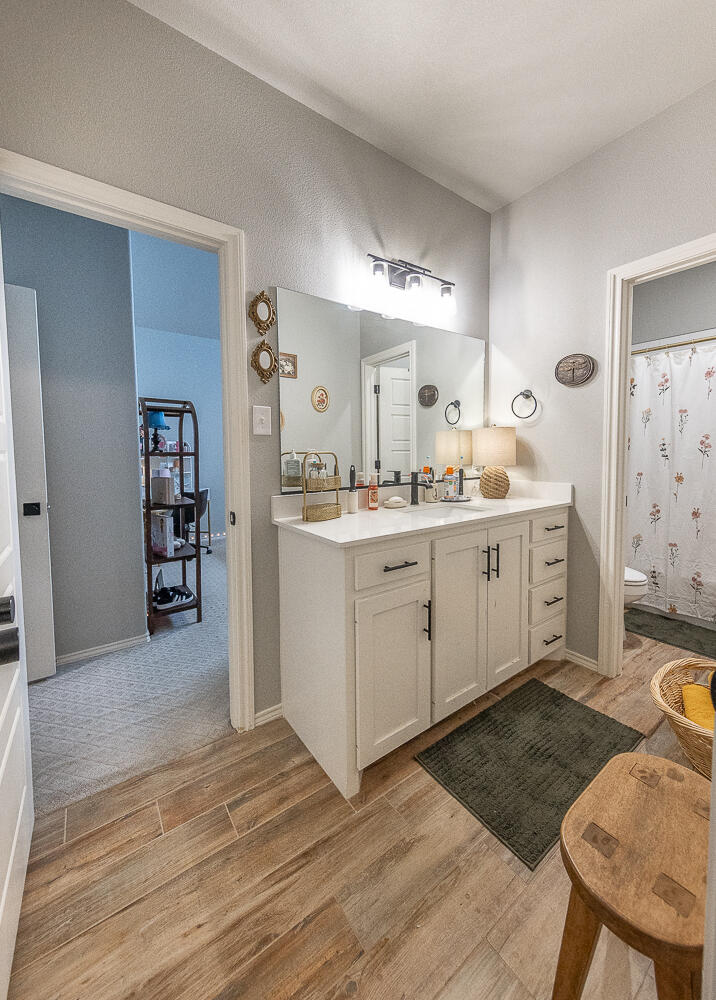 4416 140th Street Lubbock, TX 79424 - Photo 22 of 36 a kitchen with a sink a stove cabinets and wooden floor