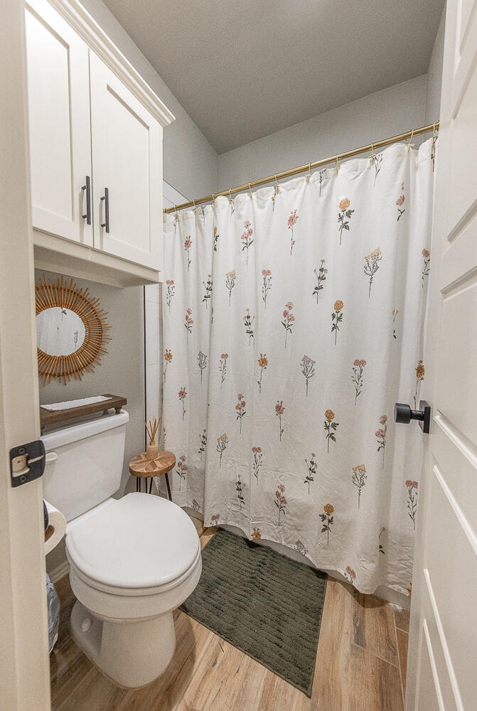 4416 140th Street Lubbock, TX 79424 - Photo 23 of 36 a bathroom with a toilet and a shower curtain