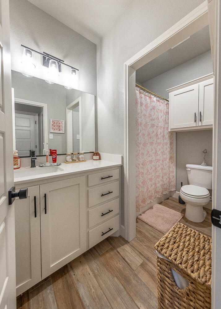 4416 140th Street Lubbock, TX 79424 - Photo 28 of 36 a bathroom with a sink a toilet and a mirror