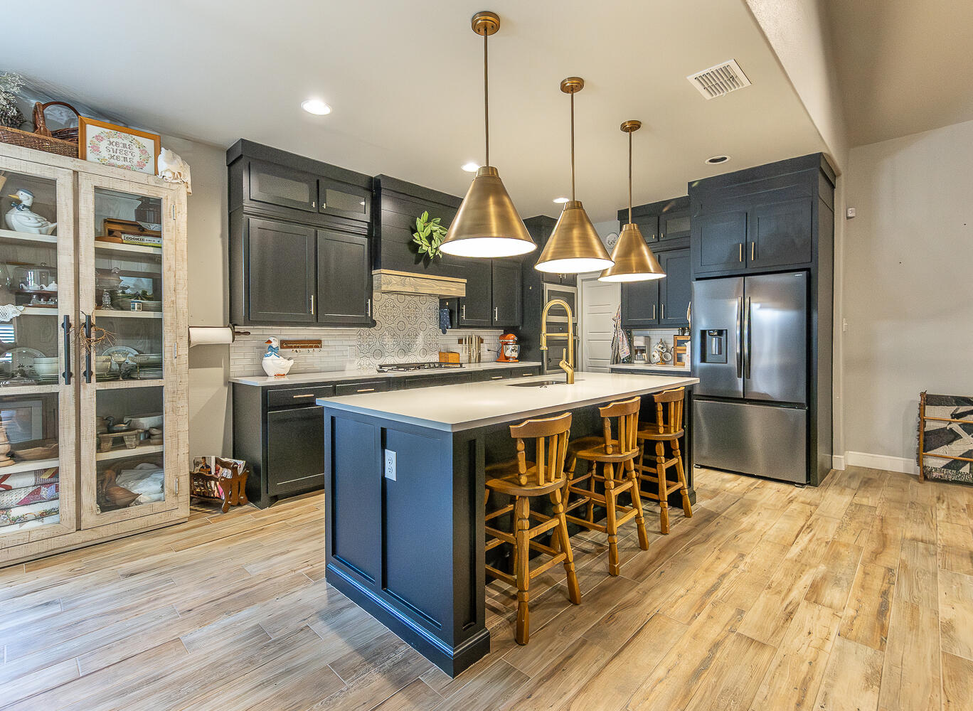 4416 140th Street Lubbock, TX 79424 - Photo 3 of 36 a kitchen with stainless steel appliances a stove a sink dishwasher a refrigerator and cabinets with wooden floor
