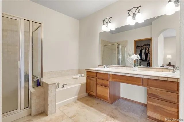 a spacious bathroom with a tub sink and a mirror
