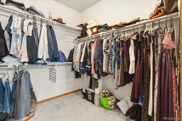 a view of walk in closet with clothes