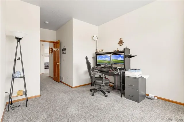 a view of a workspace with furniture and a window