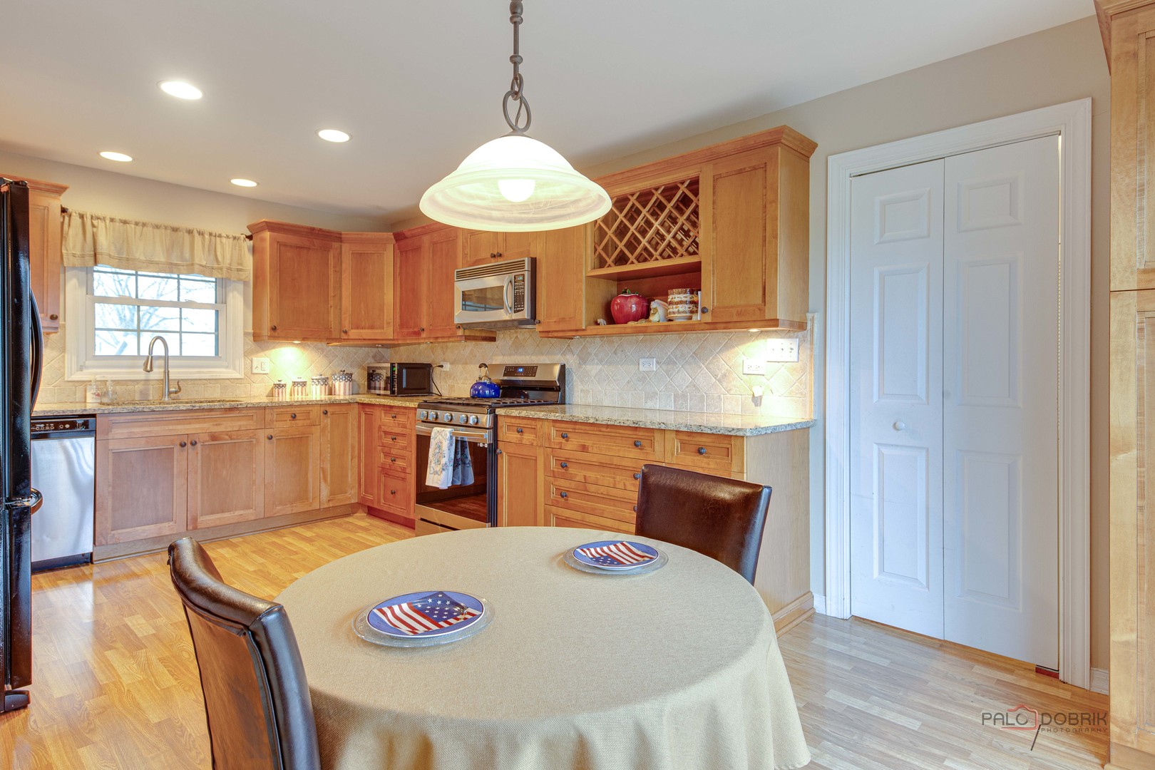 441 Arbor Gate Lane Buffalo Grove, IL 60089 - Photo 14 of 29 a kitchen with a stove a sink a kitchen island with wooden cabinets and floor