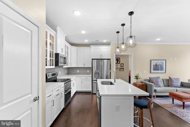a open kitchen with stainless steel appliances kitchen island a refrigerator sink and cabinets