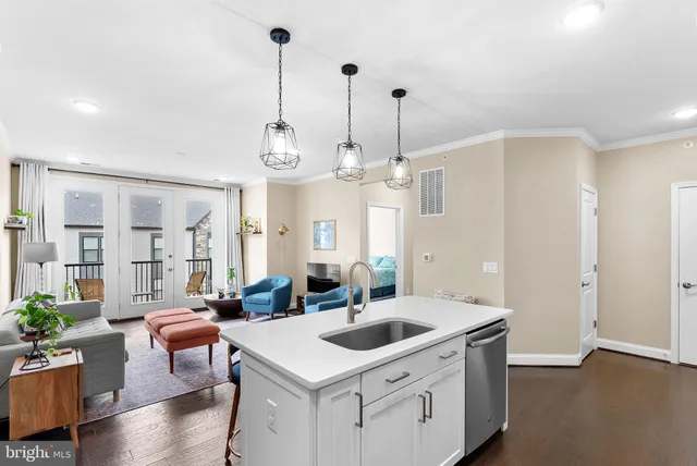 a kitchen that has a lot of cabinets a sink and a wooden floor