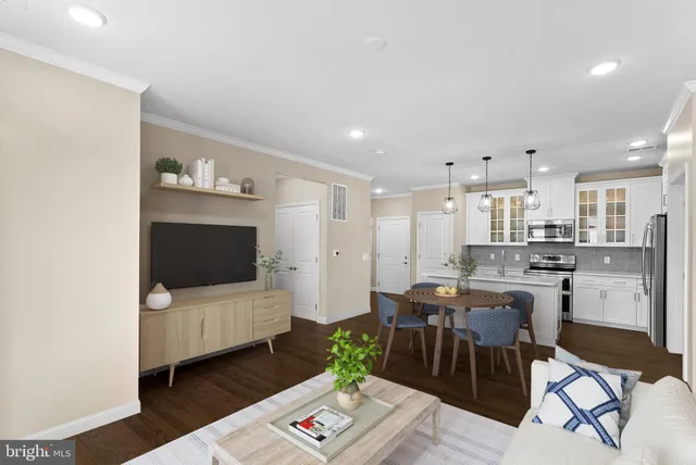 a living room with furniture a flat screen tv and kitchen view