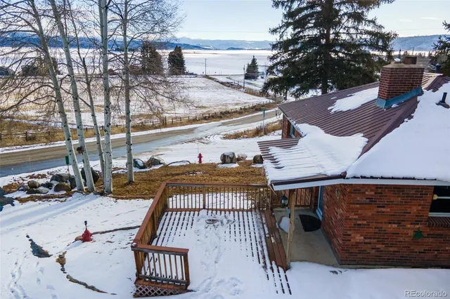 a roof deck with table and chairs and potted plants