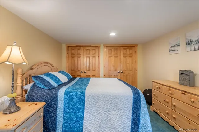 a bedroom with a bed and dresser with mirror