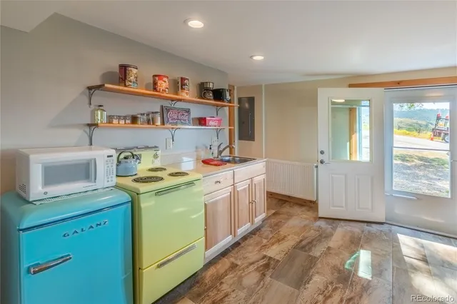 a utility room with a sink a stove and cabinets