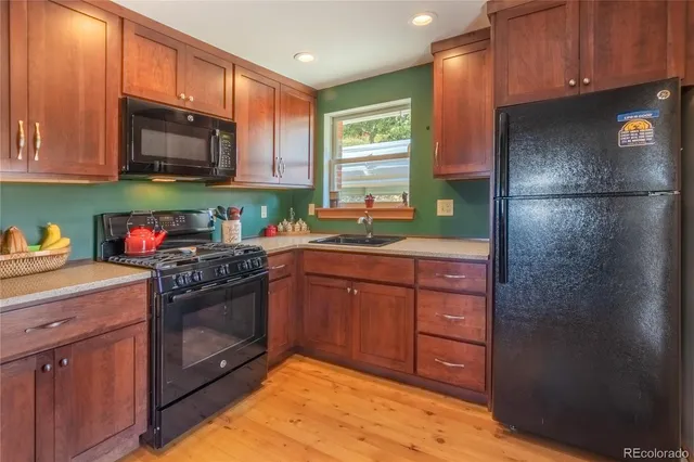 a kitchen with stainless steel appliances granite countertop a refrigerator stove and sink