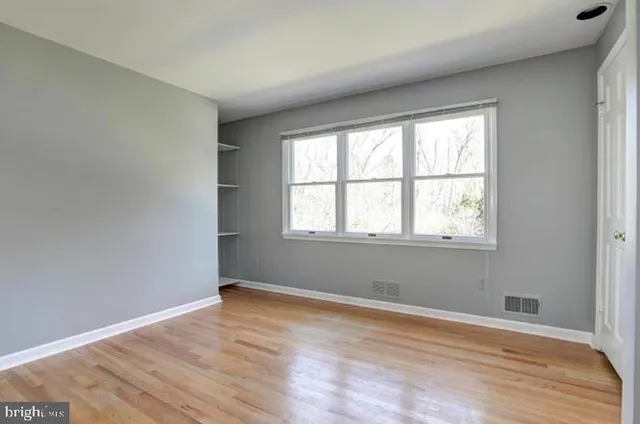 a view of a room with wooden floor and windows