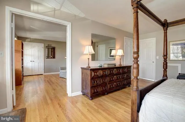 a bedroom with a bed and a mirror on dresser