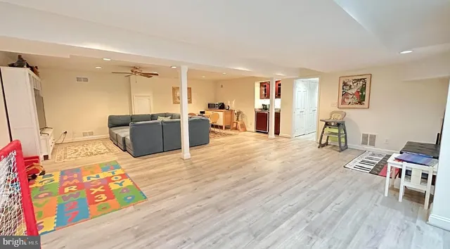 a living room with furniture a desk and chair with wooden floor