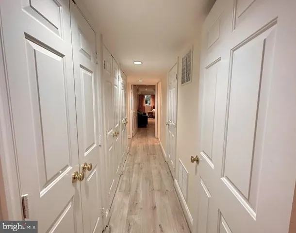 a view of a hallway with wooden floor and stairs