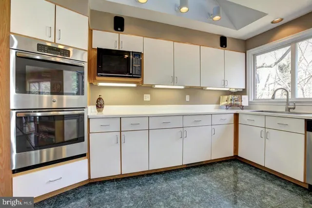 a kitchen with stainless steel appliances white cabinets and a sink