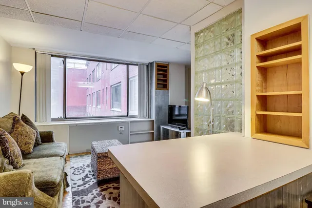 a living room with furniture a flat screen tv and a window