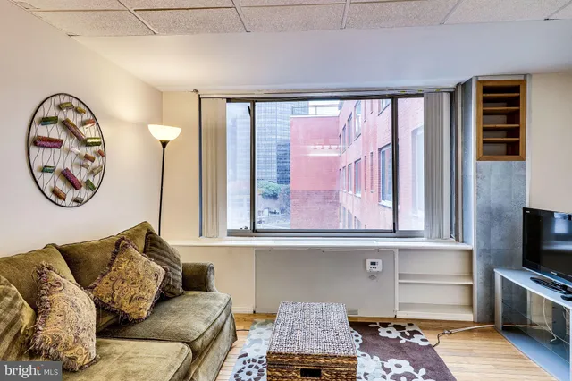 a living room with a flat screen tv and a floor to ceiling window