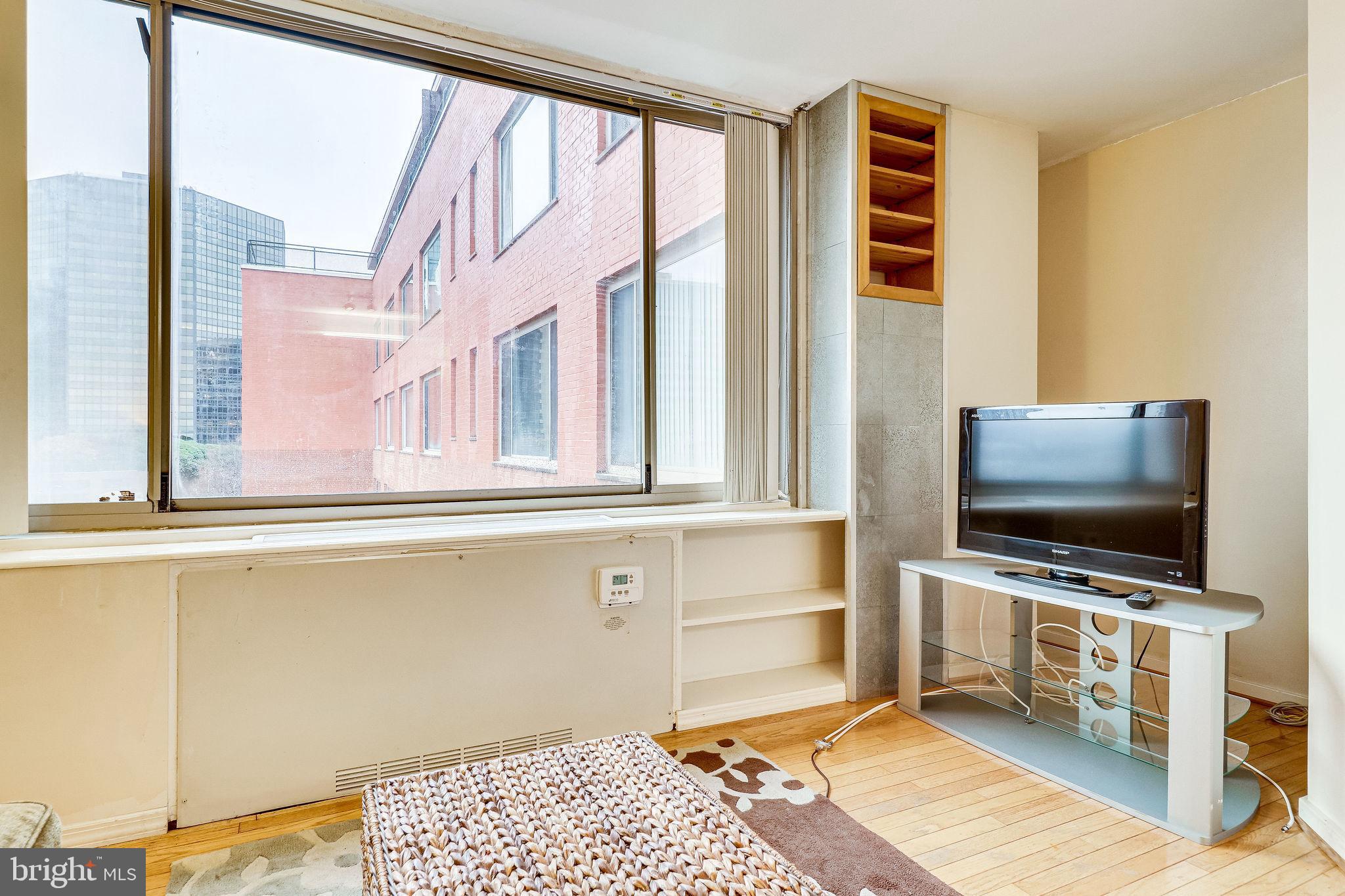 1111 Arlington Boulevard, Unit 812 Arlington, VA 22209 - Photo 14 of 37 a living room with a flat screen tv and a floor to ceiling window