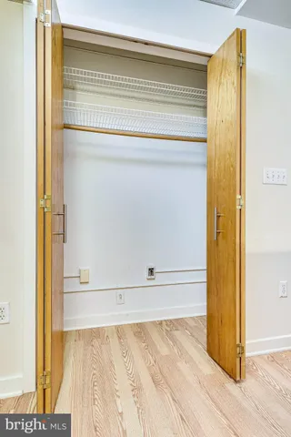 a view of a bedroom with wooden floor and a potted plant