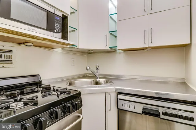 a large white bed in a bedroom next to a window