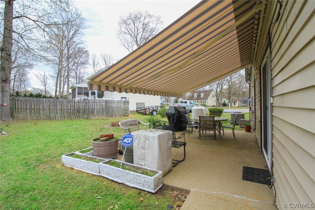 1500 Austin Road Chester, VA 23836 - Photo 7 of 30 a view of a backyard with table and chairs under an umbrella with wooden fence