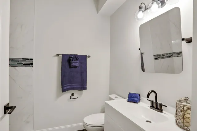 a bathroom with a toilet sink and mirror