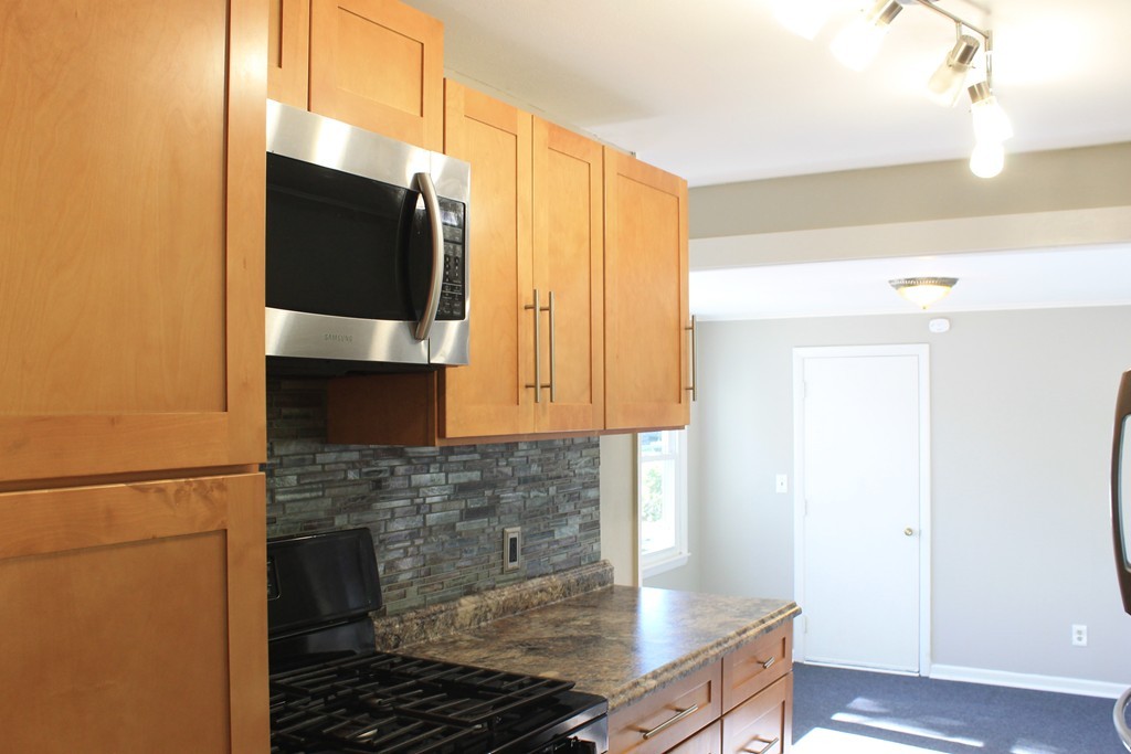 377 Stapleton Road Springfield, MA 01109 - Photo 3 of 17 a kitchen with granite countertop white cabinets and stainless steel appliances