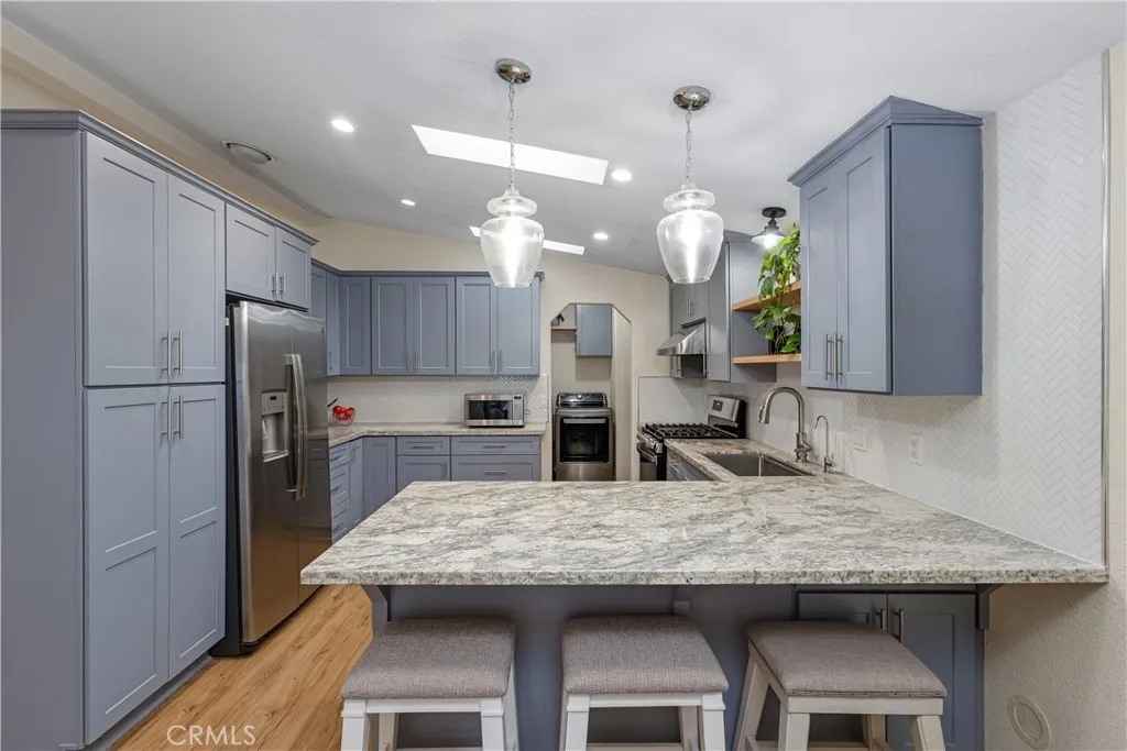 1051 Site, Unit 89 Brea, CA 92821 - Photo 16 of 36 a kitchen with granite countertop a table chairs stainless steel appliances and cabinets