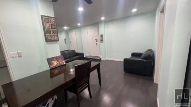 a view of a hallway with furniture and wooden floor
