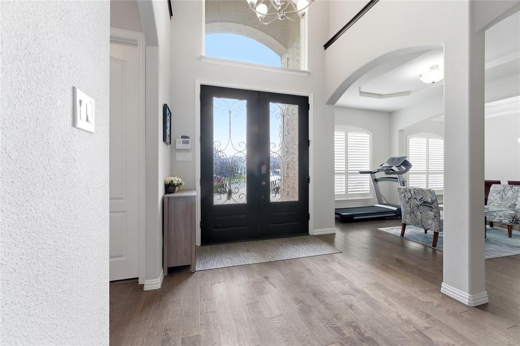 7705 Falcon Ridge Road Denton, TX 76208 - Photo 12 of 40 Foyer featuring hanging lights, light wood-style flooring, french doors, a high ceiling, and arched walkways