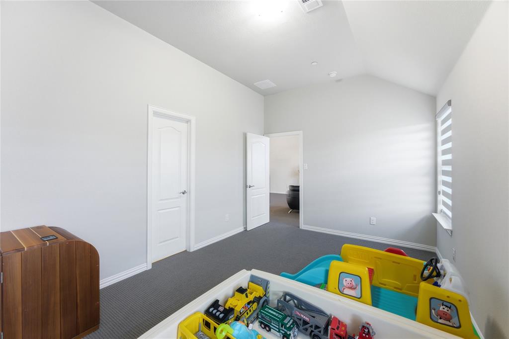 7705 Falcon Ridge Road Denton, TX 76208 - Photo 27 of 40 Bedroom with dark carpet and vaulted ceiling